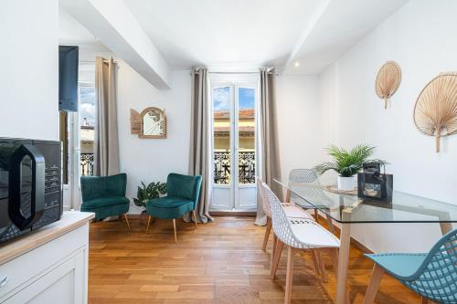 un salon avec une table et des chaises dans l'établissement Massena Street - 1 Bdr Duplex with AC & Parking, à Nice