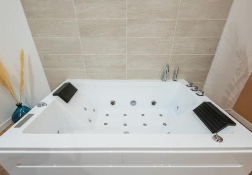 a white bath tub in a small bathroom at Charmant cocon avec jacuzzi - Bordeaux Centre in Bordeaux
