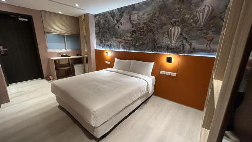 una camera con un letto bianco e un dipinto sul muro di Fashion Home Business Hotel 時尚居商旅 a Taipei