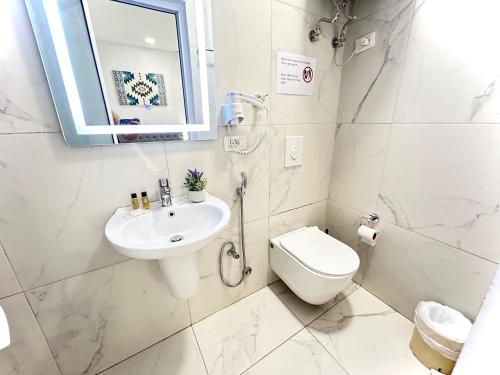 a white bathroom with a sink and a toilet at Tirana Square Hotel in Tirana