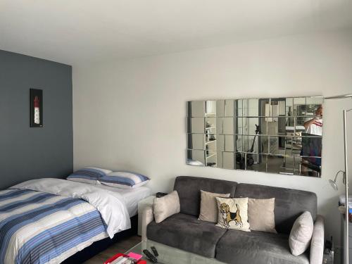 un salon avec un canapé et un lit dans l'établissement Trocadéro studio, à Paris