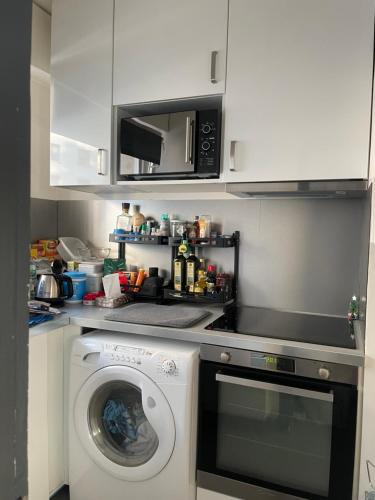 une cuisine avec un lave-linge et un micro-ondes dans l'établissement Trocadéro studio, à Paris