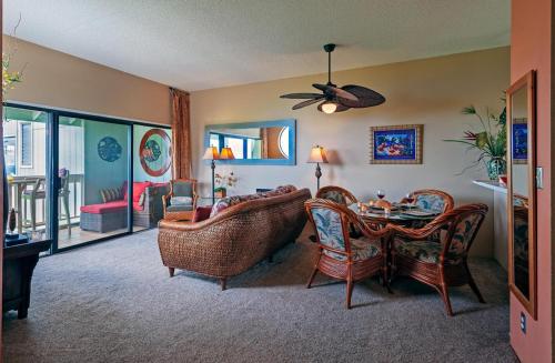a living room with a couch and a table and chairs at Kamahana 24 in Princeville
