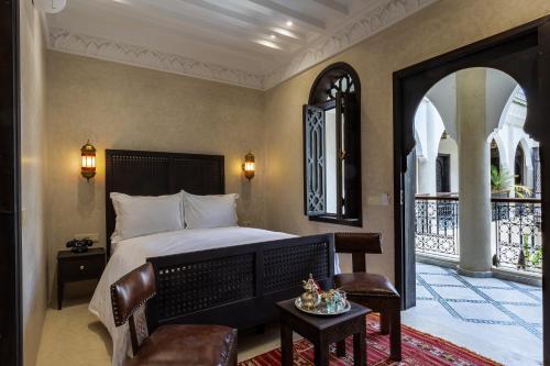 a bedroom with a bed with a chair and a table at Alrashid Marrakech Boutique Hotel & SPA in Marrakech
