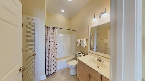 a bathroom with a sink and a toilet and a mirror at Coastal Escape at Greenhaven Inviting 4BR3BA Condo in Pawleys Island
