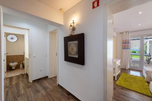 una camera con parete bianca e specchio di Luxurious BEACHFRONT VILLA de la PLAGE with private beach acces ad Albufeira