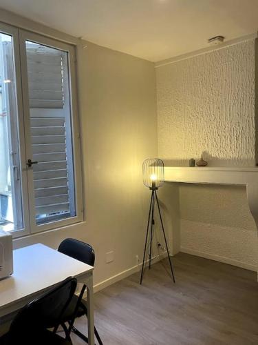 Cette chambre comprend un bureau, une table et une lampe. dans l'établissement Studio Nancy Centre-Gare !, à Nancy