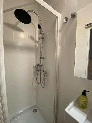 une douche avec pommeau de douche dans une salle de bain dans l'établissement Studio pieds des pistes - Cosy & Confort, à Ustou