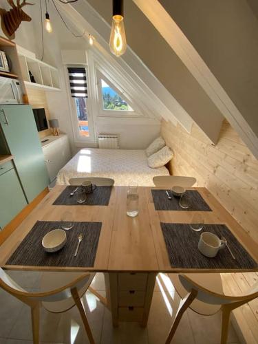 Cette chambre dispose d'une table en bois et d'un lit. dans l'établissement Studio pieds des pistes - Cosy & Confort, à Ustou