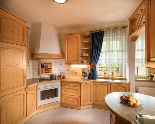 a kitchen with wooden cabinets and a table and a window at Hotel Alpenhof - New Sauna Area in Bad Hofgastein