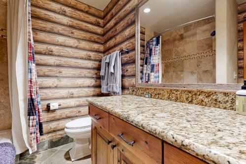 a bathroom with wooden walls and a toilet and a sink at Quittin' Time on the Woodside in Park City