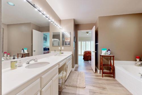 a bathroom with two sinks and a large mirror at Riviera Manor Permit# 68147 in La Quinta