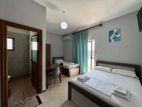 a bedroom with a bed and a desk and a bathroom at Vila Jeti in Ksamil