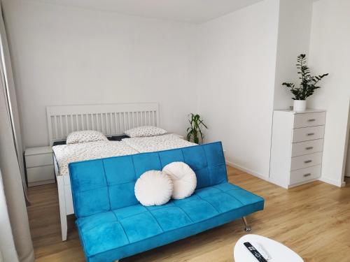 a blue couch with two white pillows in a bedroom at Prechodná stanica in Brezno