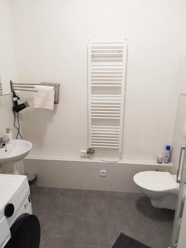 a white bathroom with a toilet and a sink at Prechodná stanica in Brezno