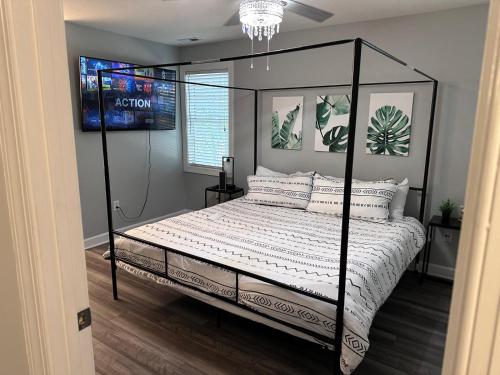a bedroom with a bed with a black frame at Simple Elegant Townhouse DT Raleigh NCSU in Raleigh
