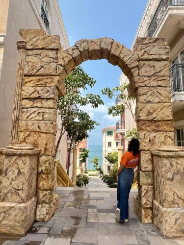 a woman standing under an archway in a street at Oscar Seaview Apartment in Phu Quoc