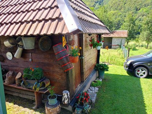 a small house with a roof and some plants at Pantića avlija - Ethno household in Požega