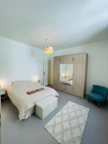 une chambre avec un lit et une chaise bleue dans l'établissement Le Duplex - Hyper Centre-Ville - 6 voyageurs, au Mans