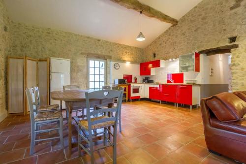 a kitchen with a table and chairs and red cabinets at Le Gavachon in Leboulin