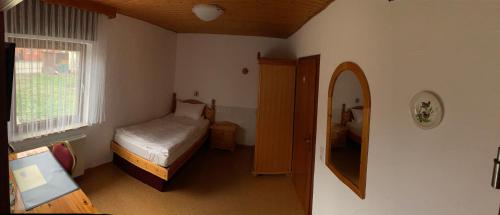 a small bedroom with a bed and a window at Hotel-Restaurant Zum Dorfkrug in Lehre