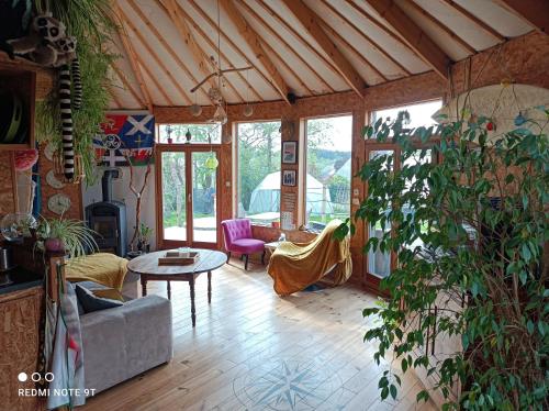 un salon avec un canapé et une table dans l'établissement Atypique yourte, à La Capelle-lès-Boulogne