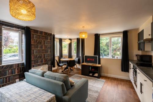 a living room with a couch and a table at Aryas Apartments Oxford - Headington in Oxford