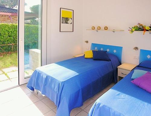 比比翁的住宿－Appartamenti Casa Del Mare，一间卧室设有两张蓝色的床和窗户