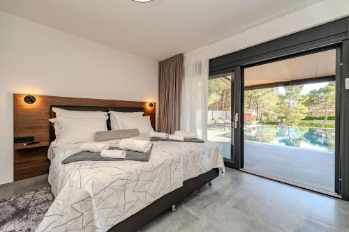 a bedroom with a large bed and a large window at Apartments Royal in Vir