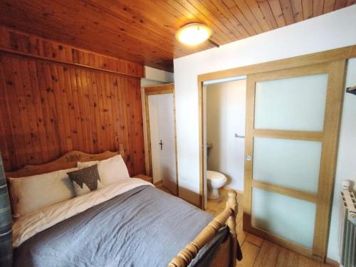 a bedroom with a bed and a door to a bathroom at Peisey Vallandry, L'appartement au pied des pistes in Landry