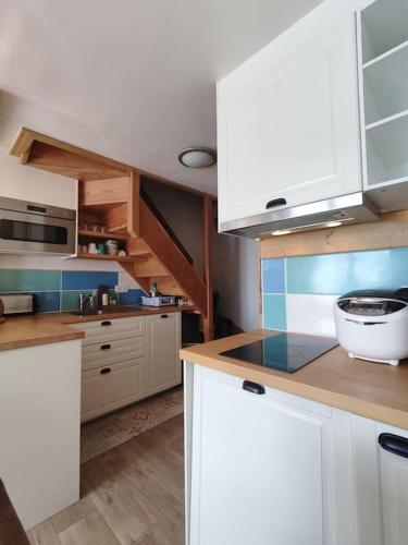 une cuisine avec des armoires blanches et un comptoir dans l'établissement Peisey Vallandry, L'appartement au pied des pistes, à Landry