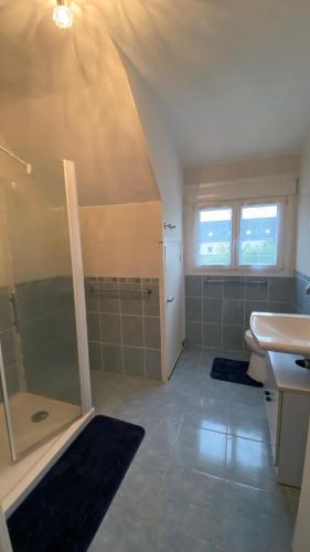 une salle de bain avec douche et lavabo dans l'établissement Maison de famille, à Sainte-Mère-Église