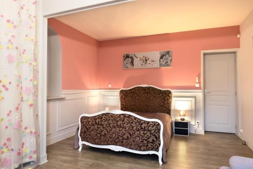 a living room with a chair and orange walls at Villa-des-eaux Claires in Puymoyen
