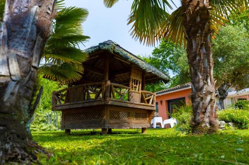a resort with a gazebo next to a palm tree at Villa-des-eaux Claires in Puymoyen