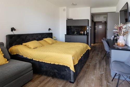 Un dormitorio con una cama y un sofá y una cocina. en Apartament Ania z widokiem na morze w Hotelu Arka, en Kołobrzeg