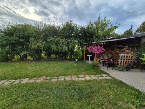 a yard with a building with a bench and flowers at Pokoje Bema 14 in Ciechocinek