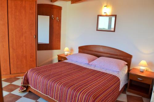 a bedroom with a bed with two night stands and a mirror at Apartments Green Village in Premantura