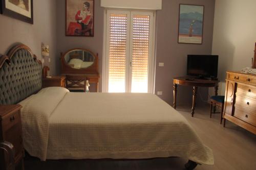 a bedroom with a bed and a dresser and a television at Roma Casetta - Tourist Rooms in Guidonia