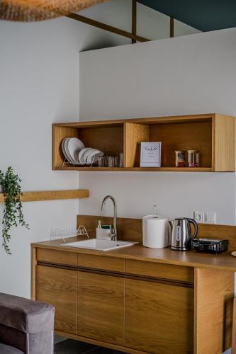 a kitchen with wooden cabinets and a sink at Take me here with a sea view by Salt Apartments in Volos
