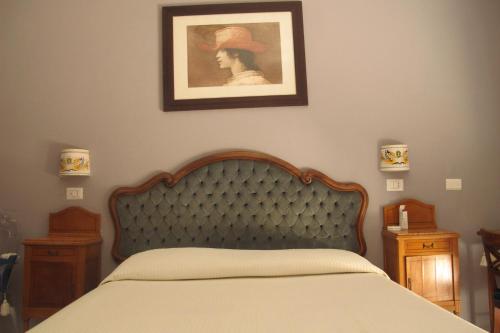 a bedroom with a bed and a picture on the wall at Roma Casetta - Tourist Rooms in Guidonia