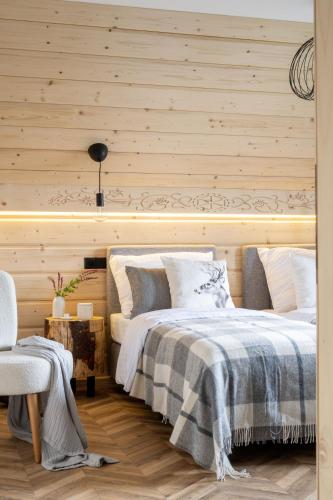 a bedroom with two beds and a wooden wall at MiLove in Milówka