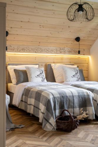 a bedroom with two beds and a wooden wall at MiLove in Milówka