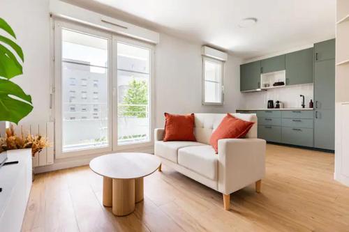 un salon avec un canapé blanc et une table dans l'établissement Appartement cosy avec terrasse proche de Paris, à Saint-Denis