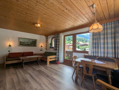 a living room with a table and chairs and a window at Bergfreund in Lermoos