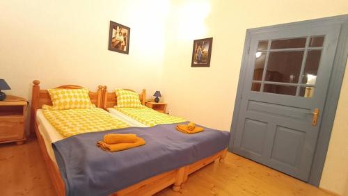 a bedroom with two beds and a blue door at Kék Mátra Vendégház in Matraszentistvan
