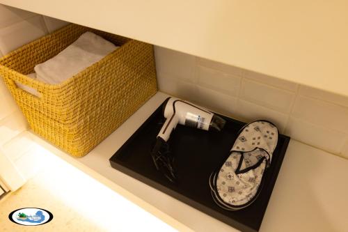 a shelf with a hair dryer and a pair of shoes at Oscar Seaview Apartment in Phu Quoc