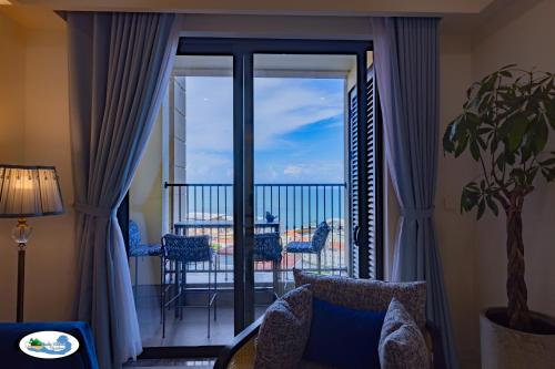 a living room with a view of a balcony at Oscar Seaview Apartment in Phu Quoc