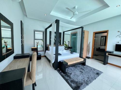 une chambre avec un lit, une table et un canapé dans l'établissement Aromdee 2 Villa by G Estate Phuket, à Ban Saiyuan (1)