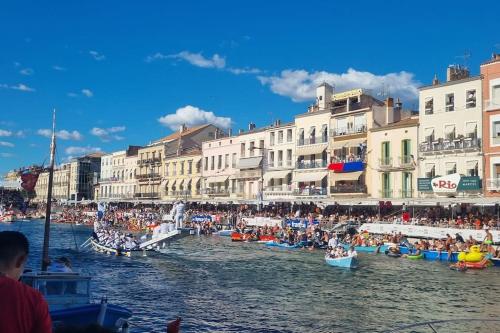 un groupe de bateaux dans une masse d'eau avec des bâtiments dans l'établissement résidence privée à Sète, Corniche, à Sète