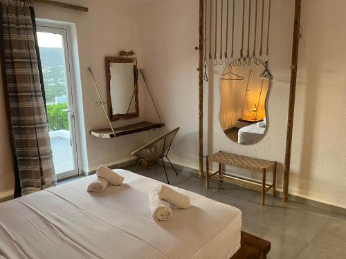 a bedroom with a bed and a mirror and a chair at Myth Experience Hercules in Agios Nikolaos